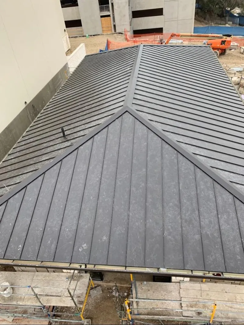 Commercial metal roof construction with crane equipment in Tanglewilde